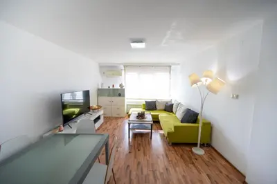 a living room with a yellow couch and a television at Bright 1BDR with Balcony in Sofia