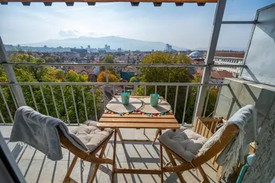 a table and chairs on a balcony with a view at Bright 1BDR with Balcony in Sofia