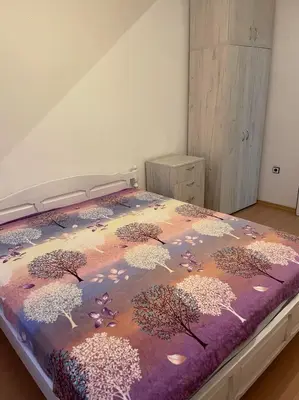 a bedroom with a bed with a colorful comforter at Лунара in Sandanski