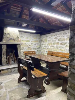 a wooden table and benches in a room with a fireplace at Forest Hill in Troyan