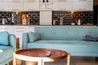a living room with a blue couch and a coffee table at Host2U New Inn 2 BD, Fireplace, Free parking in Bansko