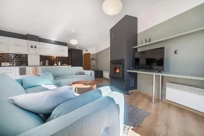 a living room with blue couches and a fireplace at Host2U New Inn 2 BD, Fireplace, Free parking in Bansko