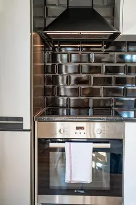 a kitchen with a stove with a towel on the oven at Host2U New Inn 2 BD, Fireplace, Free parking in Bansko