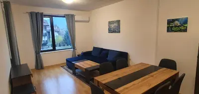 a living room with a blue couch and a table at South Mountain Apartment in Razlog