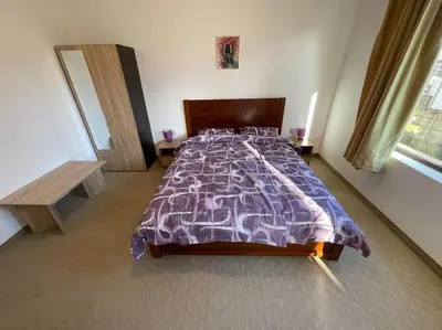 a bedroom with a large bed with a purple comforter at South Mountain Apartment in Razlog