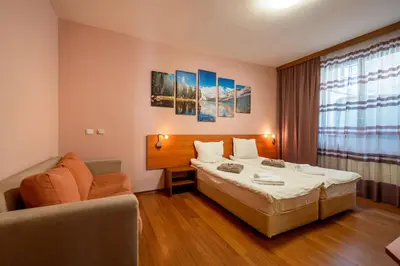 a hotel room with a bed and a couch at Chalet Bizet cosy home in BANSKO in Bansko