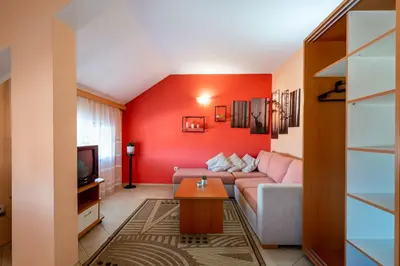 a living room with a couch and a tv at Chalet Bizet cosy home in BANSKO in Bansko