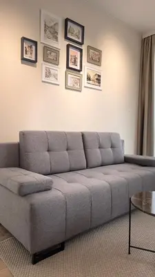 a couch in a living room with pictures on the wall at Grandma Anni's House in Plovdiv