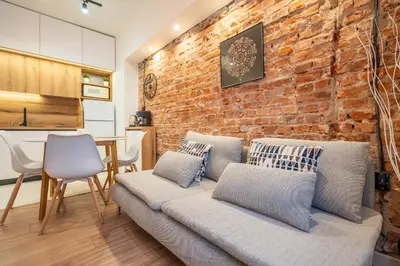 a living room with a couch and a brick wall at Nova Nook in Sofia