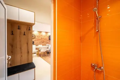 a bathroom with a shower with orange walls at Nova Nook in Sofia