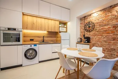 a kitchen with a table and chairs and a brick wall at Nova Nook in Sofia