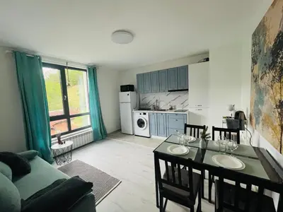 a kitchen and living room with a table and chairs at PARK ESCAPE Holiday Home 24h check in in Sandanski