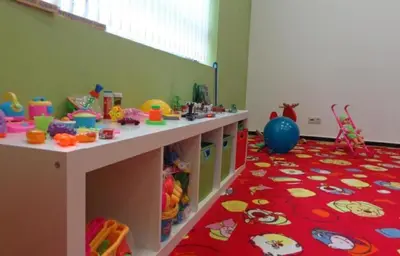 a childs play room with a table and a red carpet at Aspen Golf Apartment with Stunning Mountain View in Bansko