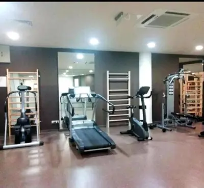 a gym with several treadmills and machines in a room at Aspen Golf Apartment with Stunning Mountain View in Bansko