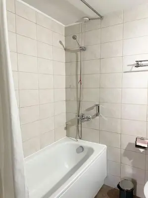 a white bathroom with a tub and a shower at Apartment Dream Bansko- 5 min walk to Gondola in Blagoevgrad
