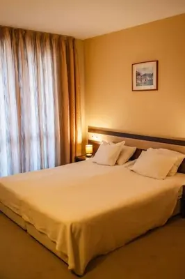 a bedroom with a large white bed with a window at Apartment Dream Bansko- 5 min walk to Gondola in Blagoevgrad