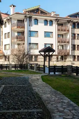 a building with a stone walkway in front of a building at Apartment Dream Bansko- 5 min walk to Gondola in Blagoevgrad