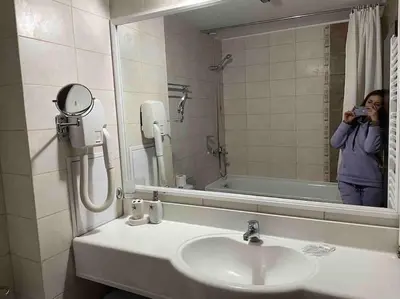 a woman taking a picture of a bathroom sink at Apartment Dream Bansko- 5 min walk to Gondola in Blagoevgrad