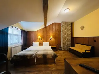 a hotel room with a bed and a couch at Фокс Хаус FOX HOUSE in Peshtera