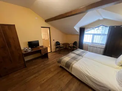 a bedroom with a bed and a desk and a television at Фокс Хаус FOX HOUSE in Peshtera