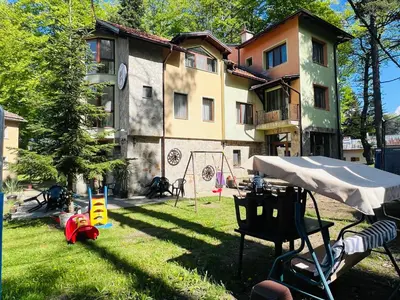 a building with a playground in front of a yard at Фокс Хаус FOX HOUSE in Peshtera