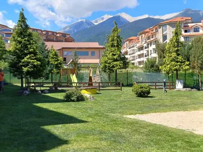 a park with a playground with mountains in the background at Apartment Melania in Complex Royal Towers in Bansko