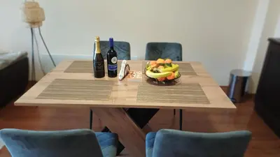 a table with a bowl of fruit and two bottles of wine at Apartment Melania in Complex Royal Towers in Bansko