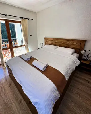 a bedroom with a large bed with two towels on it at Вила Тиара in Stoykite