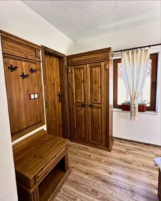 an empty room with wooden cabinets and a window at Вила Тиара in Stoykite