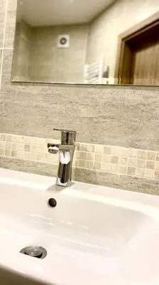 a bathroom sink with a faucet and a mirror at Bright New Apartment With Parking At The Center! in Sofia