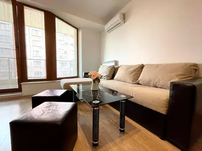 a living room with a couch and a table at Bright New Apartment With Parking At The Center! in Sofia