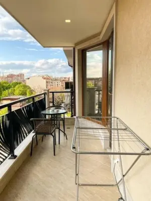 a balcony with a table and chairs on a balcony at Bright New Apartment With Parking At The Center! in Sofia