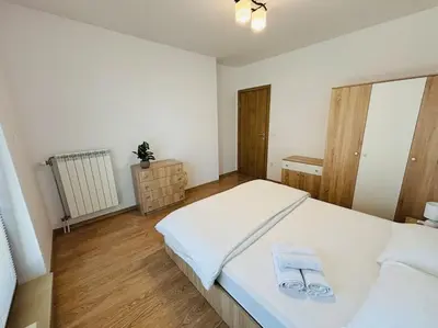 a bedroom with a large white bed with towels on it at Bright New Apartment With Parking At The Center! in Sofia