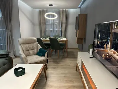 a living room with a tv and a dining room at Green Paradise - Luxurious Apartments in Plovdiv