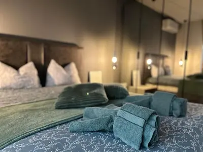 a bedroom with a bed with blue towels on it at Green Paradise - Luxurious Apartments in Plovdiv