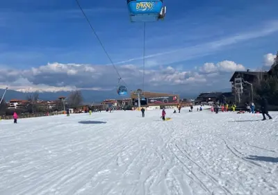 a group of people riding a ski lift in the snow at Amber - Mountain Escape with free Bottle of good Wine in Bansko
