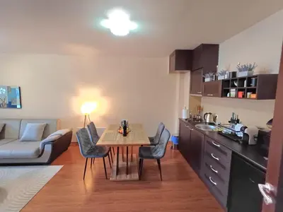 a kitchen and living room with a table and chairs at Apartment Melania in Complex Royal Towers in Bansko