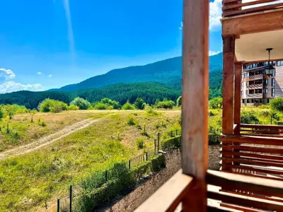 a room with a view of a field and mountains at St Ivan Ski and Spa Studio in Bansko