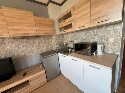 a small kitchen with white cabinets and a microwave at St Ivan Ski and Spa Studio in Bansko