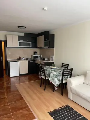 a kitchen and a living room with a table and a couch at Прекрасно място за нощувки в Пампорово in Pamporovo