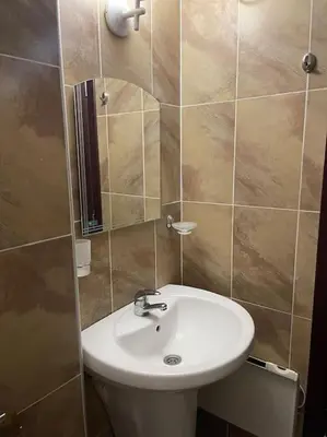 a bathroom with a white sink and a mirror at Прекрасно място за нощувки в Пампорово in Pamporovo