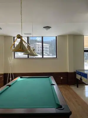 a pool table in a living room with a ceiling at Чудесно място за нощувки в Пампорово in Pamporovo