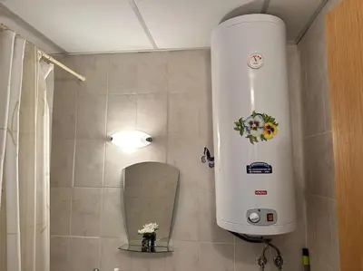 a bathroom with a water heater and a mirror at Cozy apartmen with Mountain view in Bansko