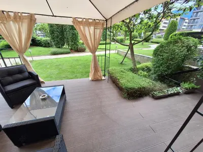 a patio with a couch and a glass table at 2 Bdr Garden Apt with Spa near Ski and Golf in Razlog