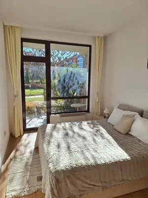 a bedroom with a bed and a large window at 2 Bdr Garden Apt with Spa near Ski and Golf in Razlog