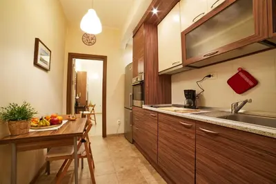 a kitchen with a sink and a table with a bowl of fruit at Central Luxury Cozy Modern Apartment in Sofia