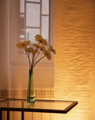 a vase with flowers sitting on a glass table at Central Luxury Cozy Modern Apartment in Sofia