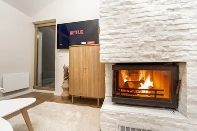 a fireplace in a living room with a fire place at Host2U Penthouse Sauna, Jacuzzi, Fireplace in Bansko