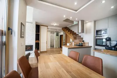 a dining room and kitchen with a table and chairs at Host2U Penthouse Sauna, Jacuzzi, Fireplace in Bansko