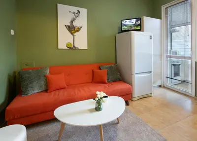 a living room with a red couch and a white table at Groovy Olive Apartment in Troyan
